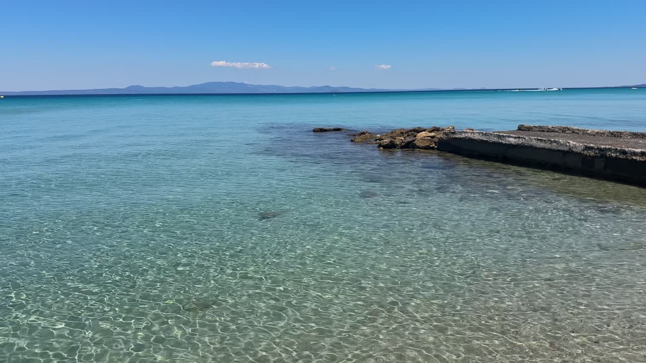 Stunning beach scene in Halkidiki, Greece, with elegant sunbeds facing the crystal-clear turquoise sea. A perfect summer escape in the heart of the Aegean.