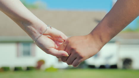 a young couple holding hands against the backdrop of their new home buying real estate concept a dre