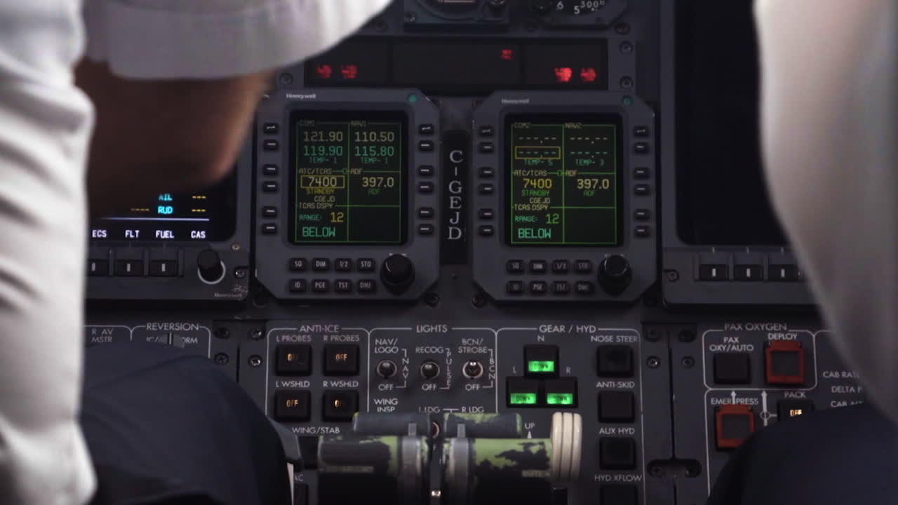 An aircraft pilot and his copilot press buttons and switches on the cockpit dashboard.