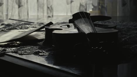 Antique classical violin lays on piano, soft window light SLIDE reveal