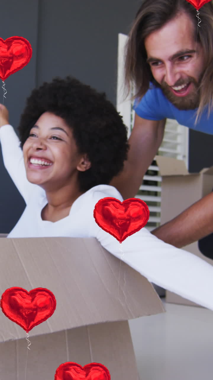 animación de iconos de corazón sobre una feliz pareja diversa que se muda a casa