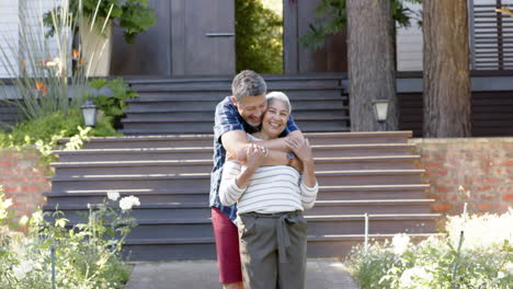 Happy-biracial-senior-couple-embracing-in-sunny-garden