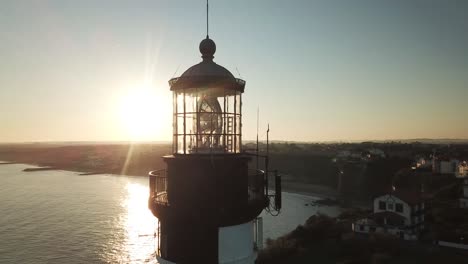 drone flying around biarritz lighthouse at sunset with sea in background, france