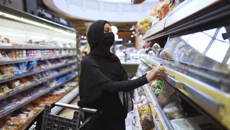 muslim woman in a bakery section at the supermarket