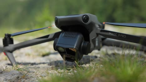 close up of camera drone on ground outdoors with hand turning on the quadcopter