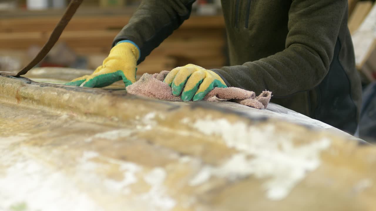 Wiping down bottom of sanded fiberglass boat before painting