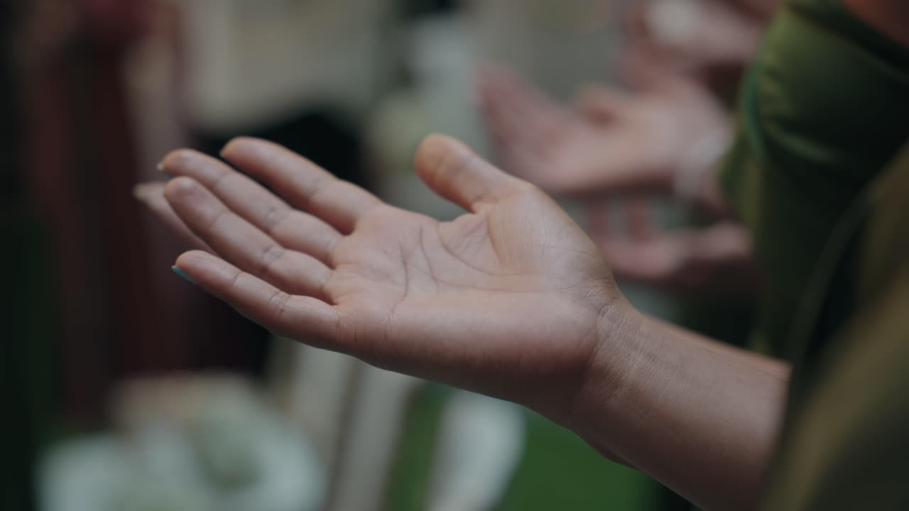 extended open palm in calm gesture during a ceremonial gathering