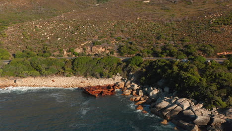 shipwreck on rocky coastline of beach in cape town, south africa