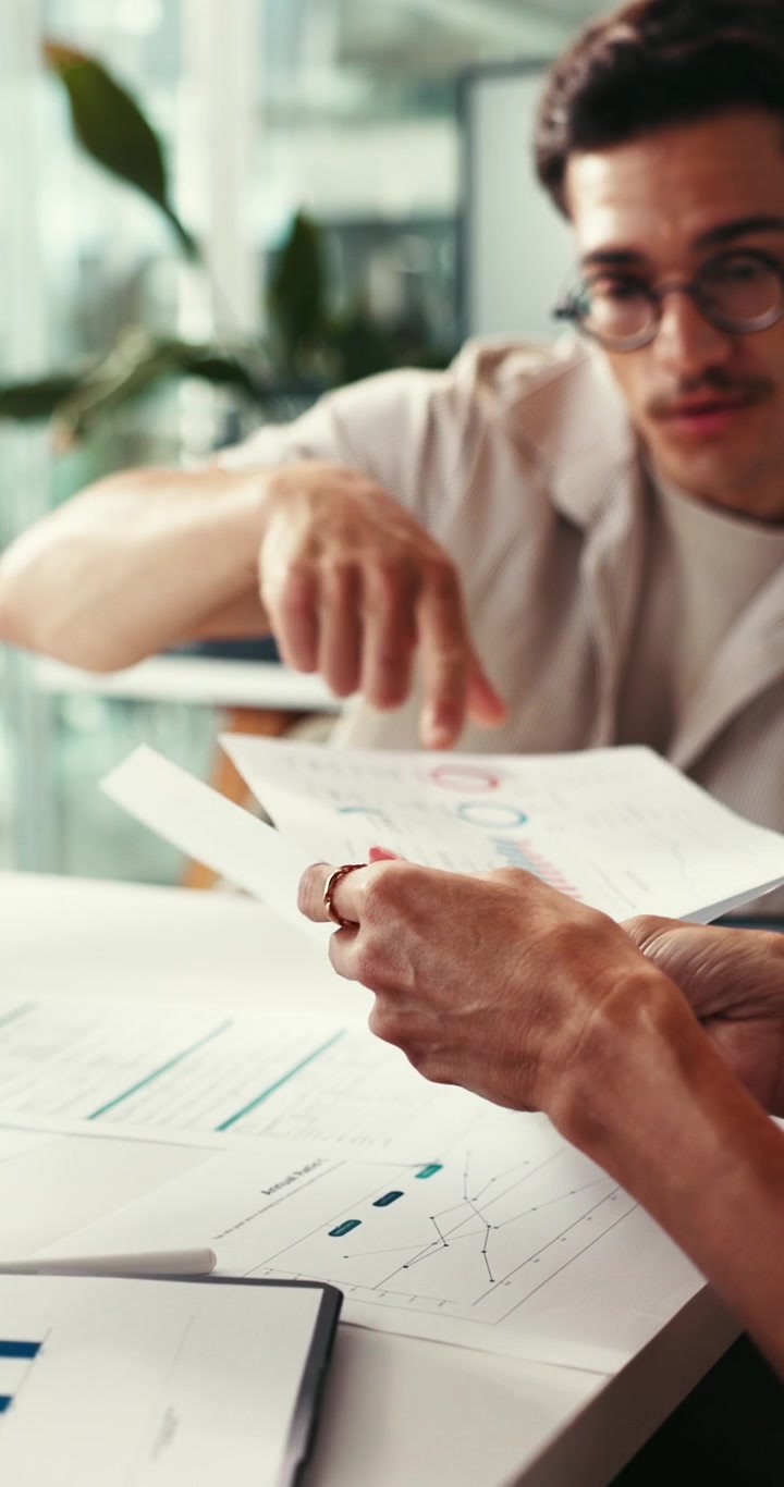 Colleghi che analizzano grafici finanziari e dati durante una riunione in ufficio