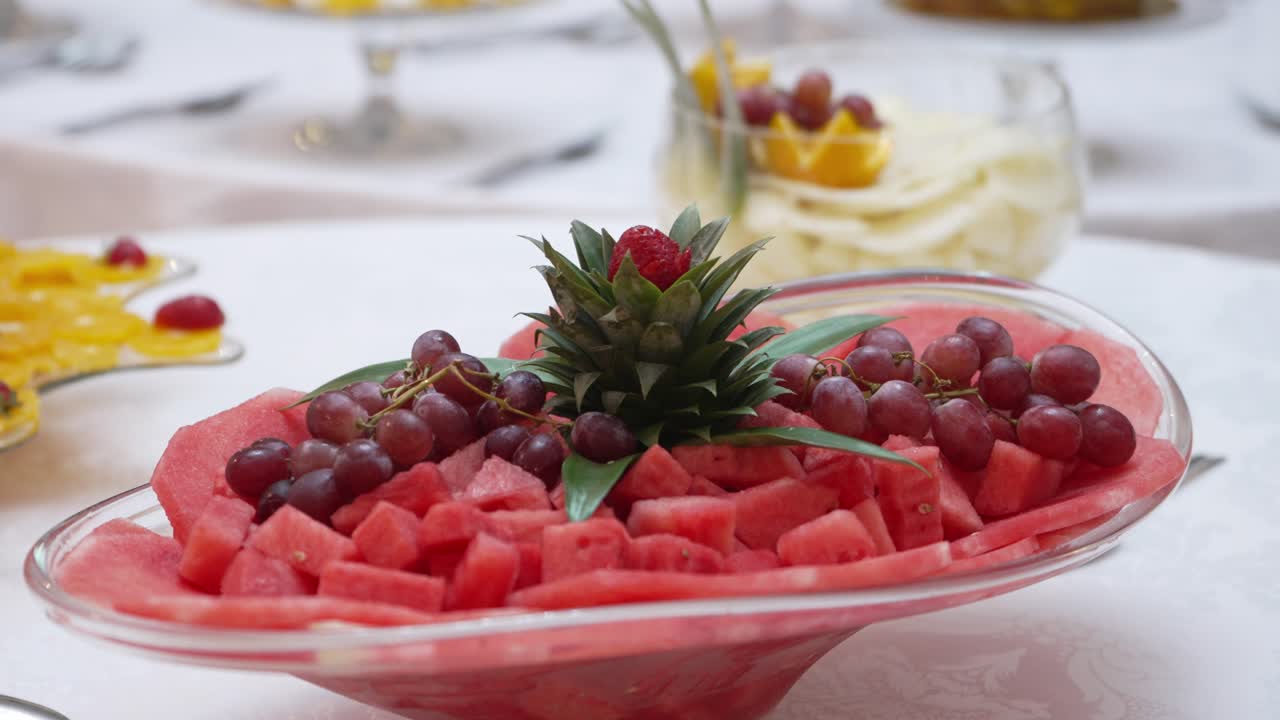 Fresh fruit platter with watermelon, grapes, and pineapple garnish, arranged for a buffet