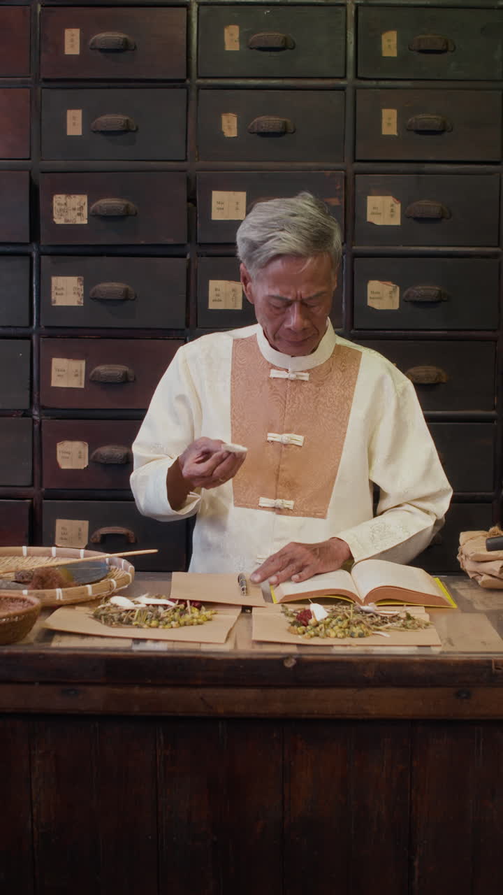 Senior Homeopath Writing Ingredients of Healing Mixture at Herbal APothecary