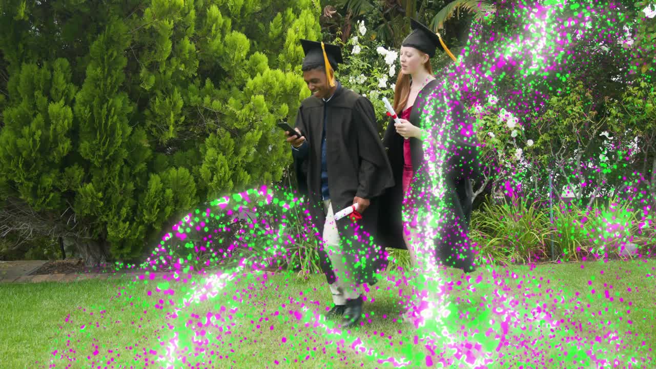 Grads walking linking arms raising phone taking selfie marking graduation with confetti drifting by