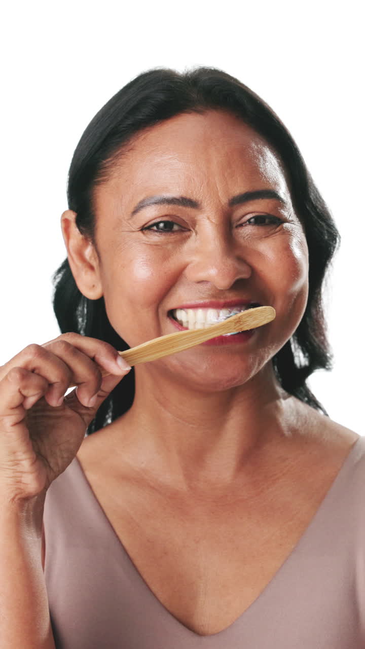 Happy Woman Brushing Teeth with Bamboo Toothbrush on White Background