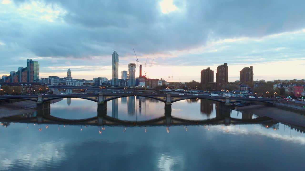 Op- en neergaand droneschot van verkeer op Battersea Bridge en Chelsea Harbour Londen bij zonsondergang
