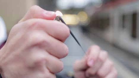 hands lighting a spark in an outdoor setting with blurred background