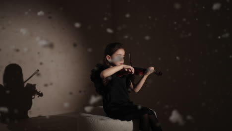 young girl playing violin in a wintery setting