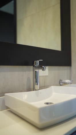 bathroom sink and faucet in hotel or home with modern design and mirror