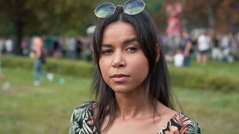 close up of multiracial woman looking at camera at music festival.