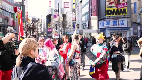 performers in vibrant attire dancing in a busy city