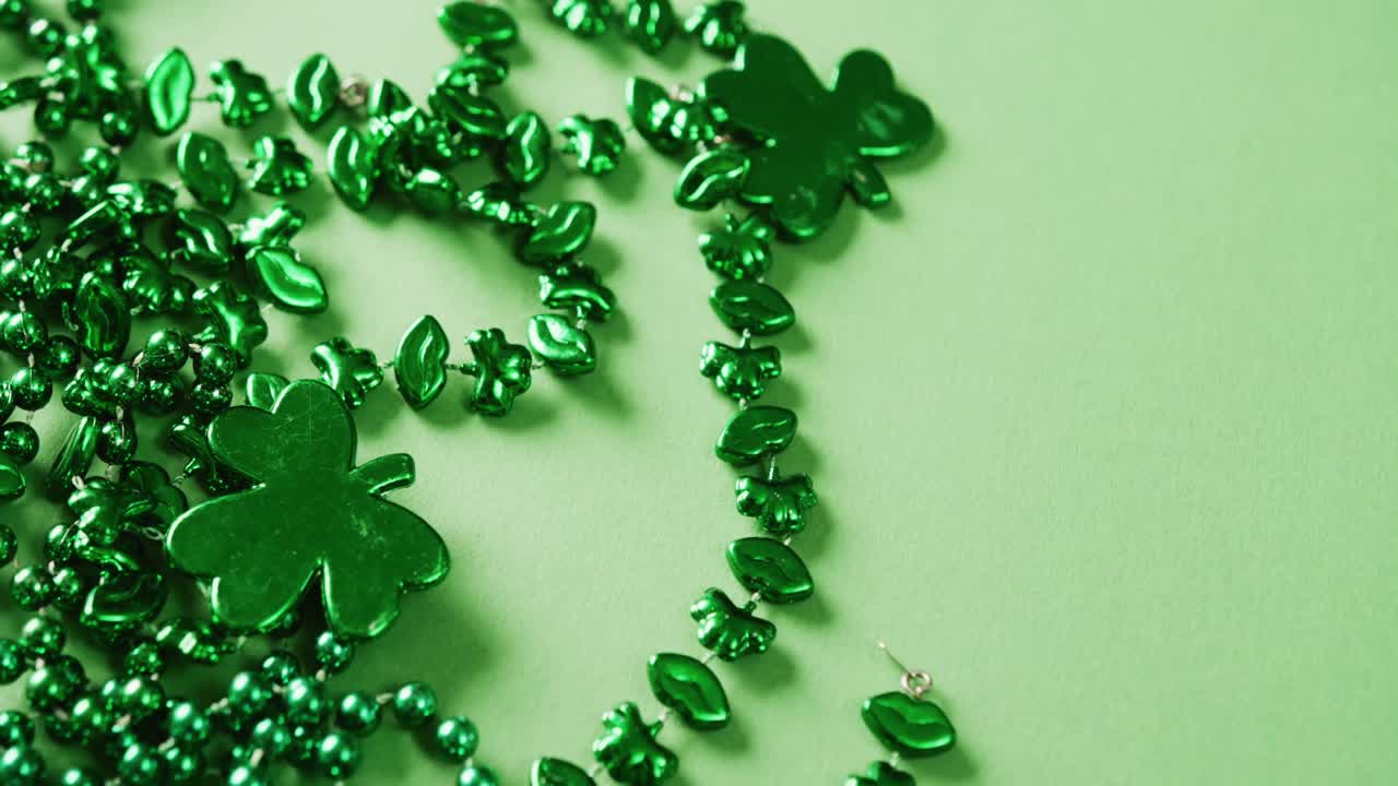 Video of st patrick's green shamrock and necklace on green background