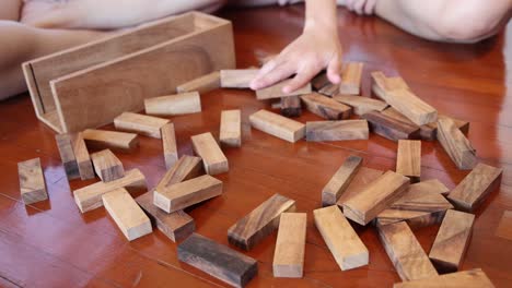 hands meticulously constructing a block tower.