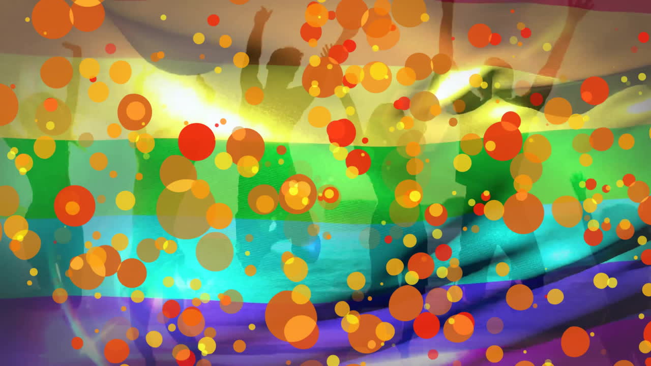 Dancing silhouettes moving across shallow beach water, with rainbow stripes and confetti