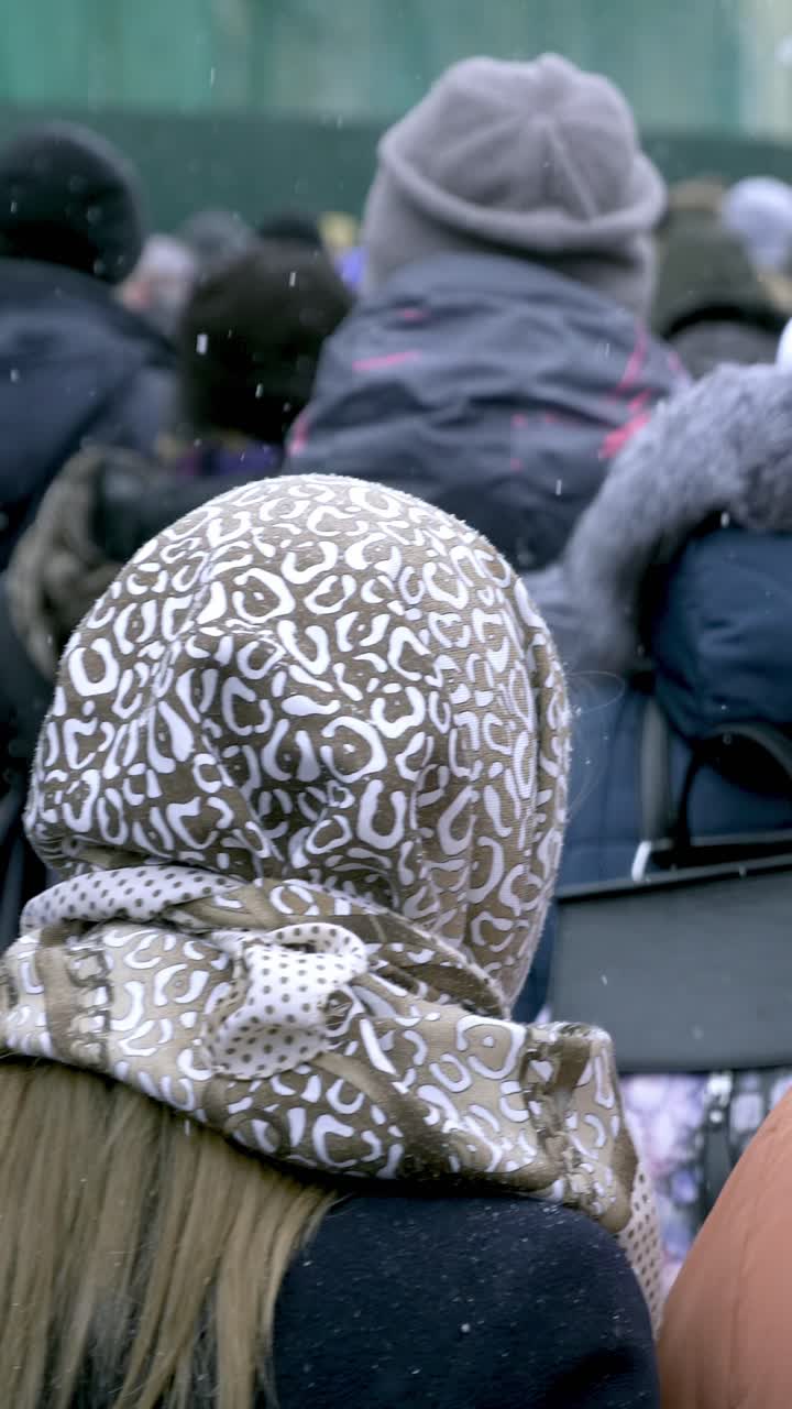 Group of people wearing winter coats in a snowy environment, showcasing diverse styles and colors, creating a sense of community and togetherness