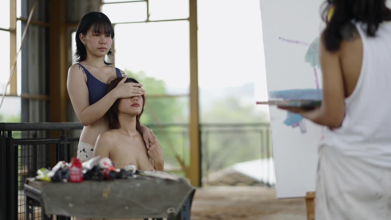 Artists engaged in painting a portrait of a model