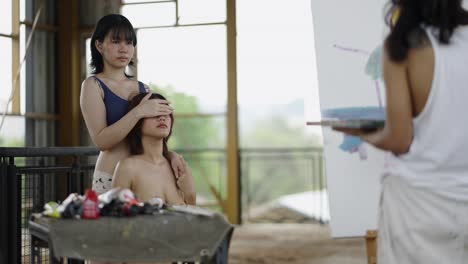 artists engaged in painting a portrait of a model