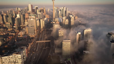 the sun setting over a foggy toronto skyline