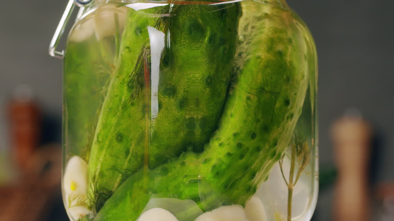 Close-up of fermented cucumbers with garlic in can. Preservation of vegetables in glass jars. Fermentation preserved cucumbers with spices. Russian cuisine.