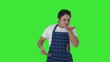 cocinero indio feliz degustando buena comida y mostrando bien señal de pantalla verde
