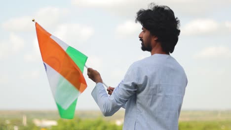 Der-Junge-Mann-Mit-Traditioneller-Indischer-Kleidung,-Die-An-Einem-Sonnigen-Tag-Die-Indische-Flagge-Hält