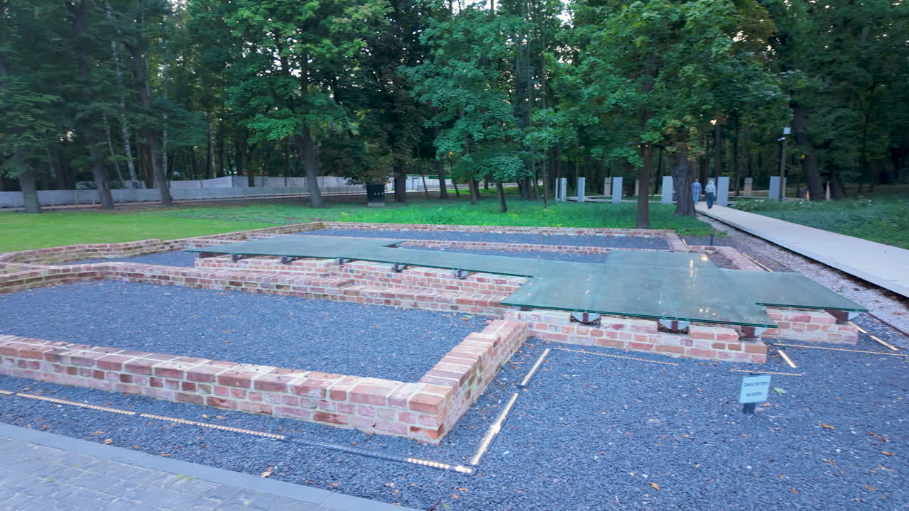 Ruiner af det tidligere vagthus eller kasernefundament ved Westerplatte, bevaret med lave murstensvægge og dækket med beskyttende glas og grus