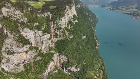 drone view of seerenbachfälle waterfall and walensee lake in betlis, switzerland, alpine cliffs, blue water and lush green views