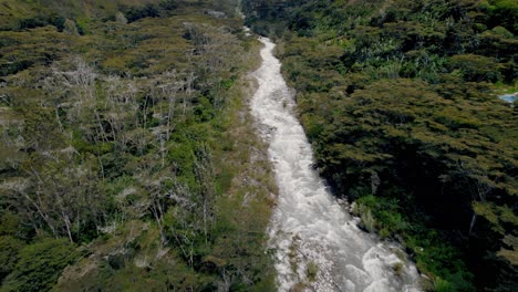 Birds-eye-view-over-flowing-river-troubled-water-across-Peruvian-forest-in-Peru