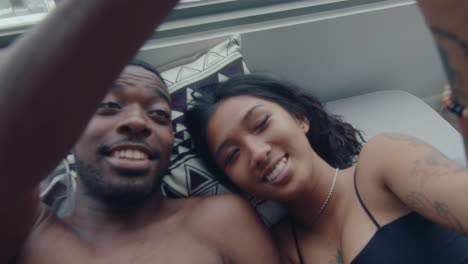 affectionate boyfriend and girlfriend touching hands in bed