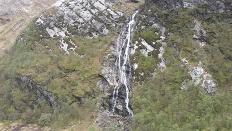 Drone-view-of-a-spectacular-waterfall-located-in-Glen-Nevis,-Scotland