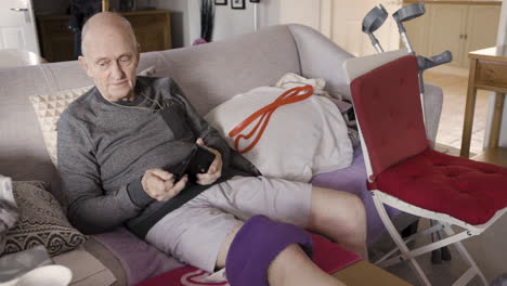 elderly man relaxing on couch with knee support