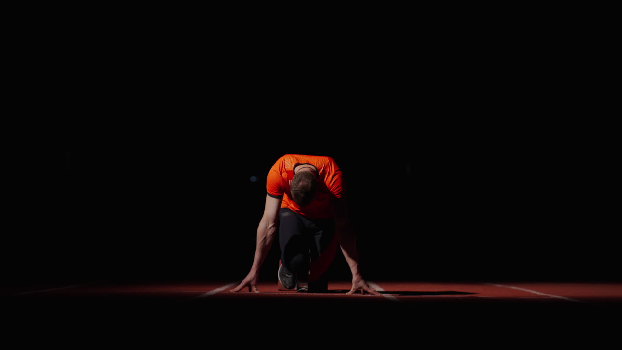 corredor en posición de salida por la noche