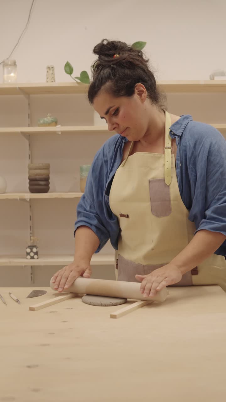 Woman rolling clay in ceramics studio