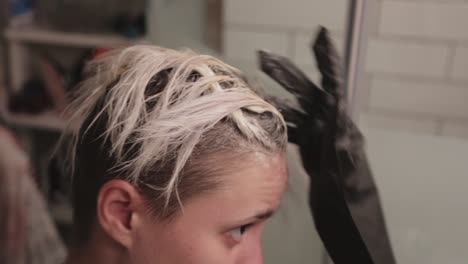 A-Short-Haired-Young-Woman-Bleaching-Hair-While-Brushing-It-With-Her-Fingers---Close-Up-Shot