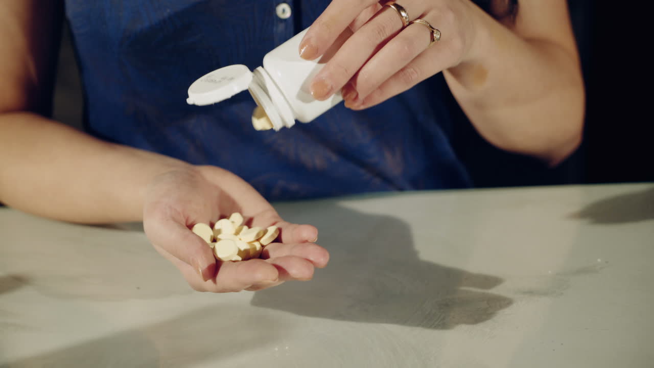 One step from death. Close up of pills in hands of young depressed girl holding them and going to take
