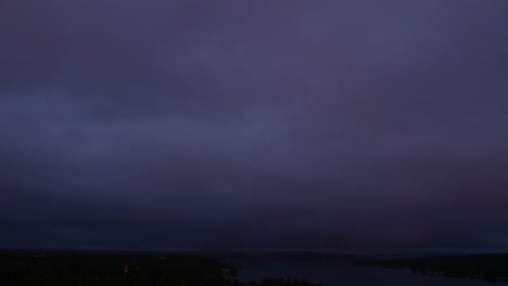 puesta de sol naranja y púrpura oscura, nubes en flujo, arco iris desvanecido, hiperlapso aéreo