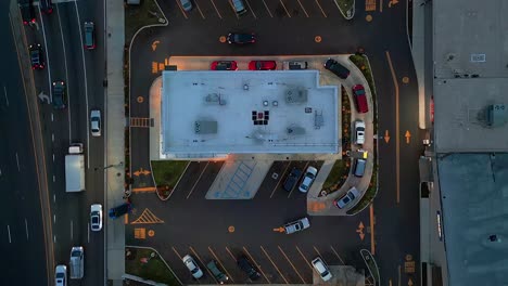 a top down, aerial view directly over a busy fast food restaurant with a drive through for orders on the go