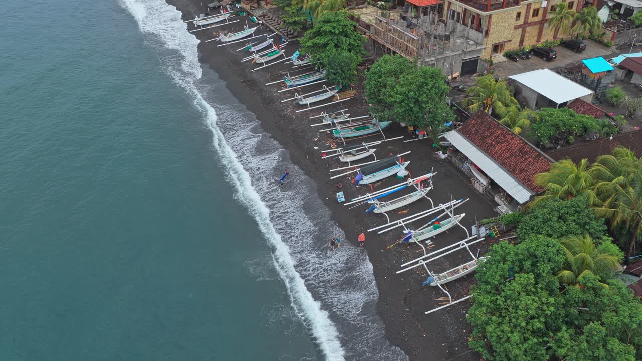 Aerial view of amed black sand beach with traditional jukung fishing boats