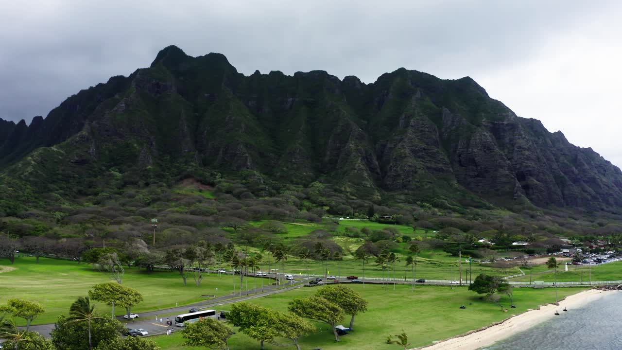 Drone shot of the mountains from Jurassic Park looming over Hawaii's shoreline.