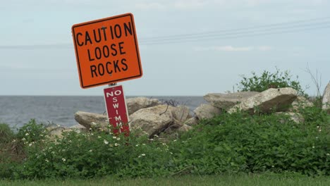 caution loose rocks no swimming waring sign lake pontchartrain