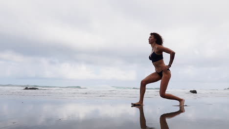 Realizando-Ejercicios-Relajantes-Junto-Al-Mar,-Una-Atleta-Se-Une-A-Una-Mujer-Fitness-En-Estiramientos-De-Piernas-O-Estocadas-En-La-Playa,-Todo-En-Cámara-Lenta