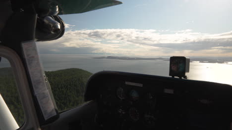 aircraft flying over the forested land and coastal landscape of san juan islands in washington state, us